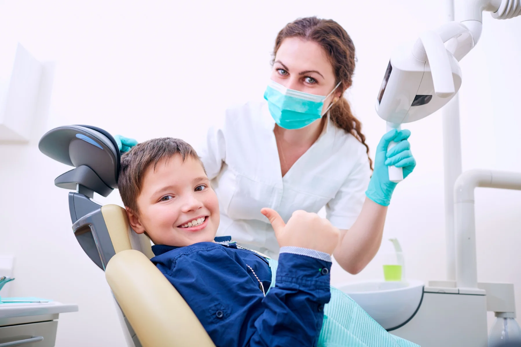 Child giving a thumbs up in the dental chair
