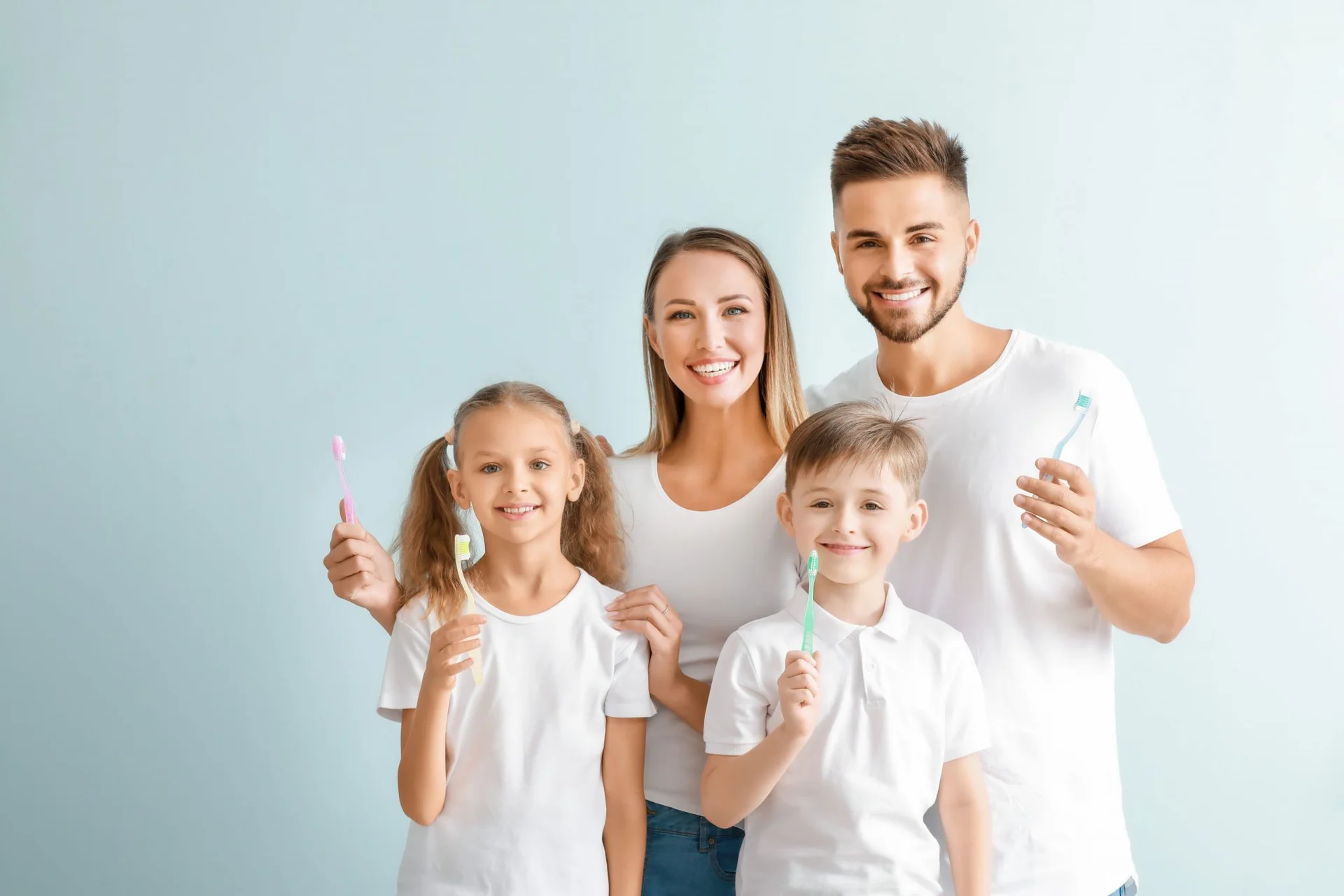 Smiling family holding their toothbrushes together